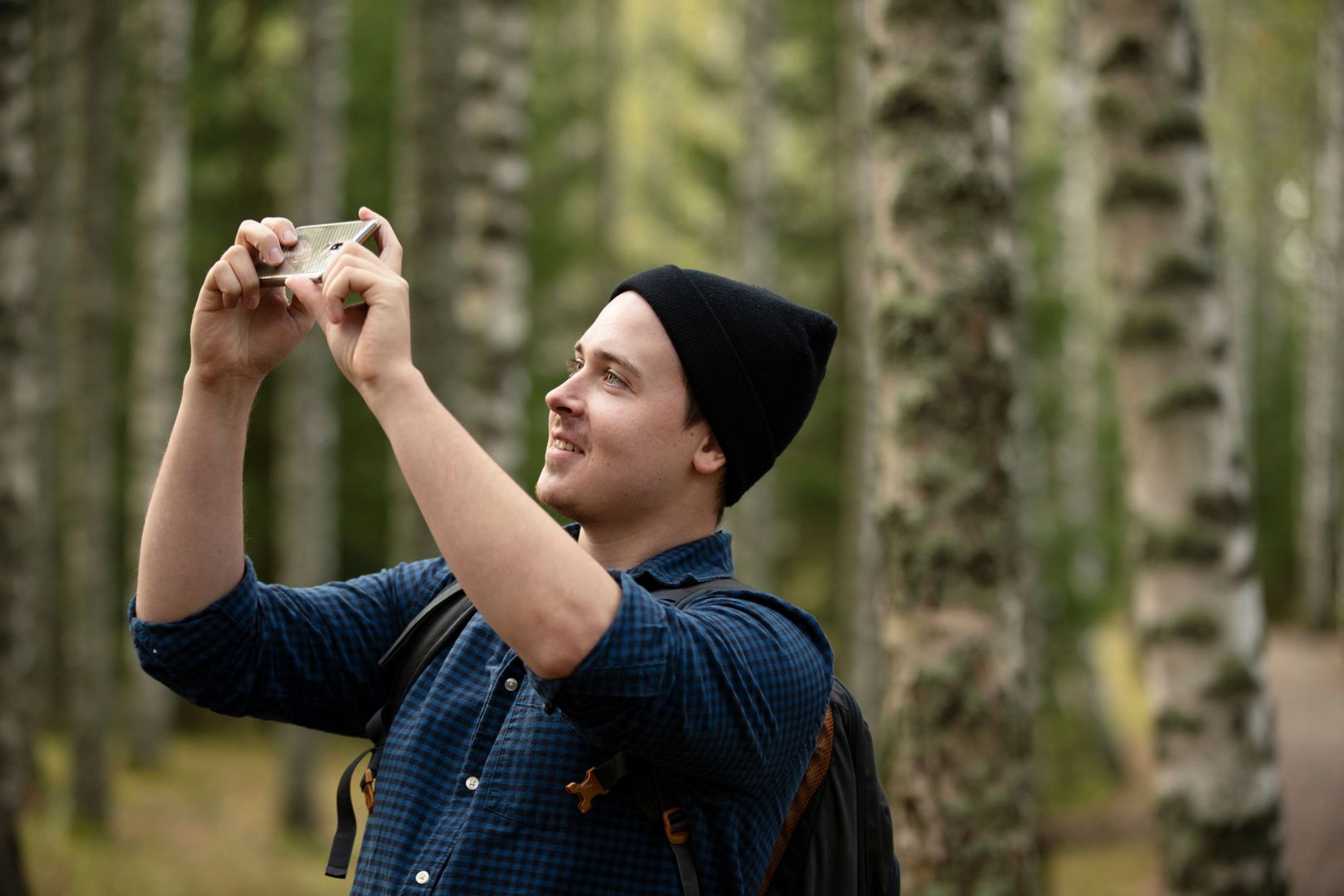 VK mies valokuvaa metsassa kolilla